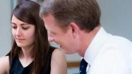 Student works with her professor in a classroom.