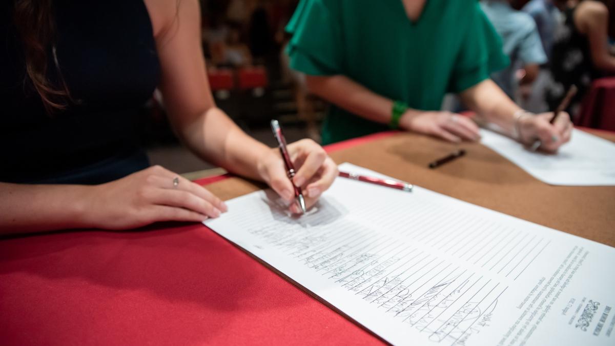 学生 sign the honor code during new student convocation.