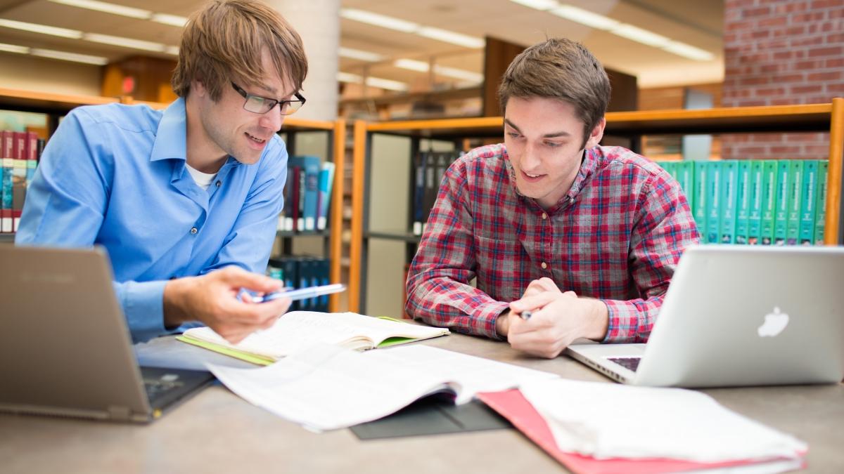 Mason Stark and John Burnam working on research in the library