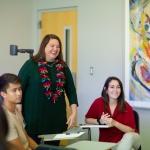 Heather Haynes Smith stands with two students in a classroom